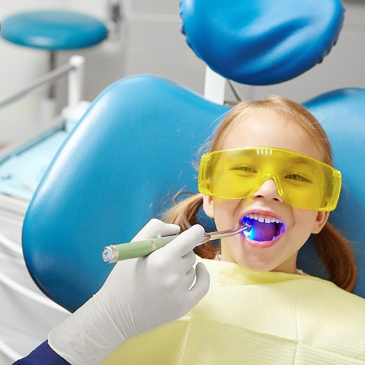 Child smiling during dental sealant treatment