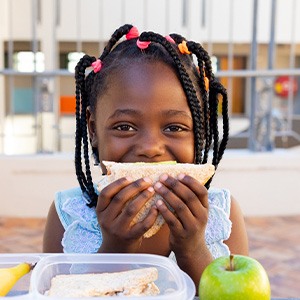 Child smiling while eating lunch at school