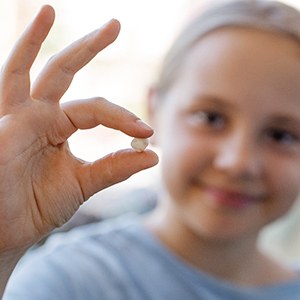 Child holding her extracted tooth