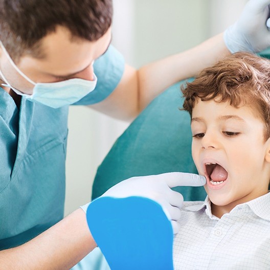 Child looking at molars in mirror with dentist
