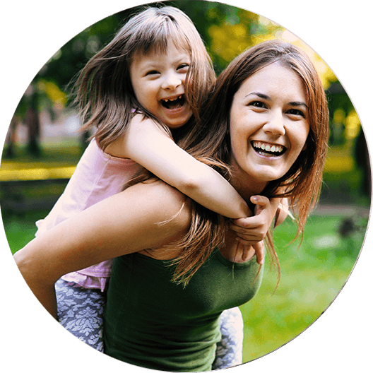 Mother giving laughing daughter a piggy back ride