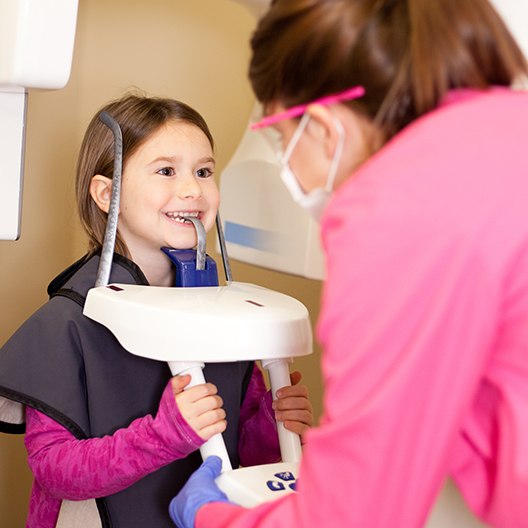 Dental team member capturing 3 D C T scan of young patient's smile