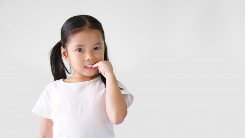 Young girl biting her fingernail