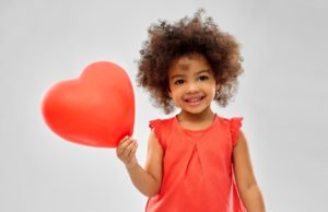 smiling girl holding a heart