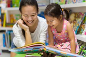 Mother and daughter reading children's books about dental visits