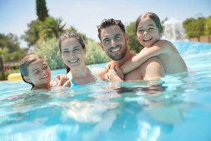 family of four swimming in a pool 