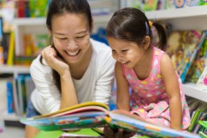 Mother and child reading book together