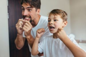 father teaching his son to floss 