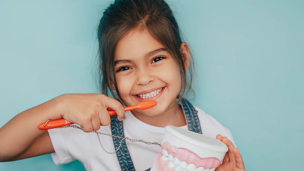 A young girl brushing her teeth.