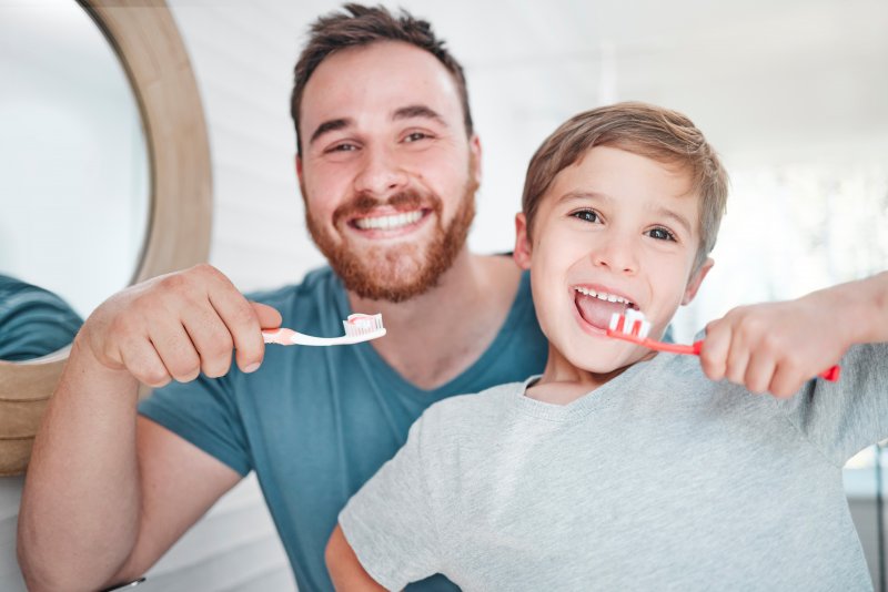 dad and son brushing teeth