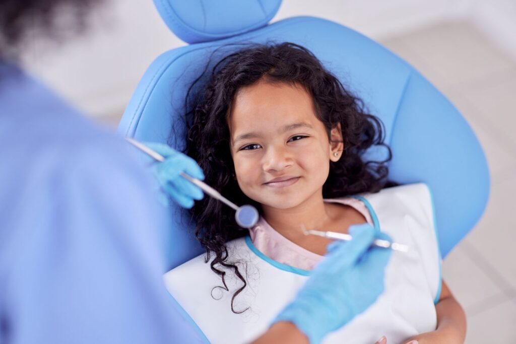 A little girl smiling in a dentist’s chair