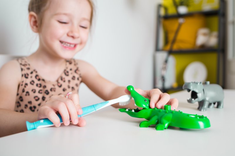 Child with good oral health playing with a dental toy